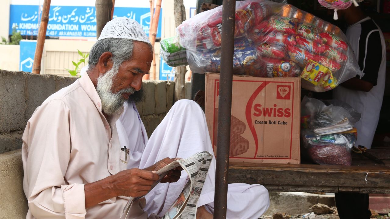 A Rohingya man reads a newspaper in Arkanabad.