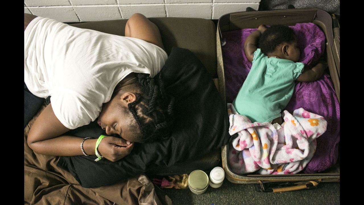 Michele Snelling sleeps on couch cushions next to her 4-month-old daughter, Lauryn, at a middle school in St. Petersburg, Florida, on September 11. The school was filled with evacuees.