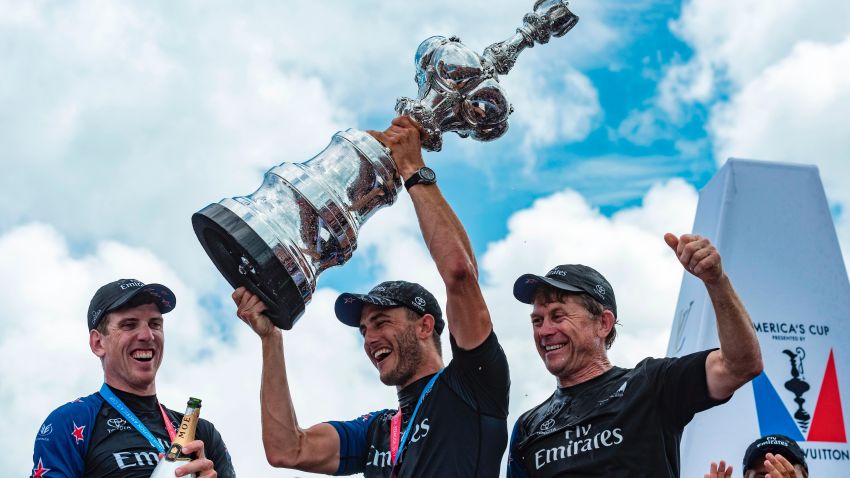 Emirates Team New Zealand helmsman Peter Burling and trimmer Blair Tuke and shore crew manager Sean Regan hoist the America's Cup in the Great Sound during the 35th America's Cup June 26, 2017 in Hamilton, Bermuda. / AFP PHOTO / Chris CAMERON        (Photo credit should read CHRIS CAMERON/AFP/Getty Images)