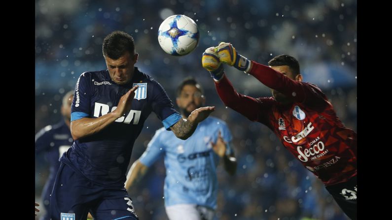 Temperley goalkeeper Josue Ayala tries to punch the ball away from Racing Club forward Enrique Triverio during a league match in Avellaneda, Argentina, on Saturday, September 9.