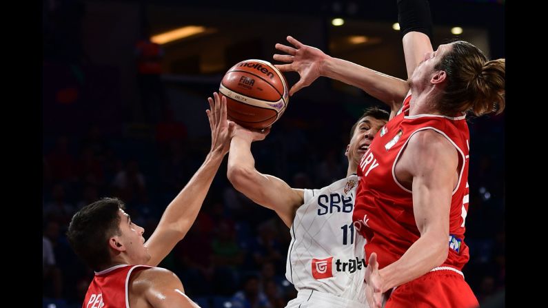 Serbian forward Vladimir Lucic, center, is defended by Hungary's Akos Keller, left, and Zoltan Perl during a EuroBasket game in Istanbul on Sunday, September 10. Serbia won 86-78 to advance to the quarterfinals.