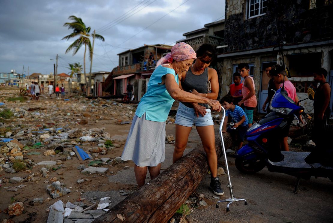 People make their way through debris in the Cojimar neighborhood of Havana.