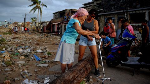 People make their way through debris in the Cojimar neighborhood of Havana.