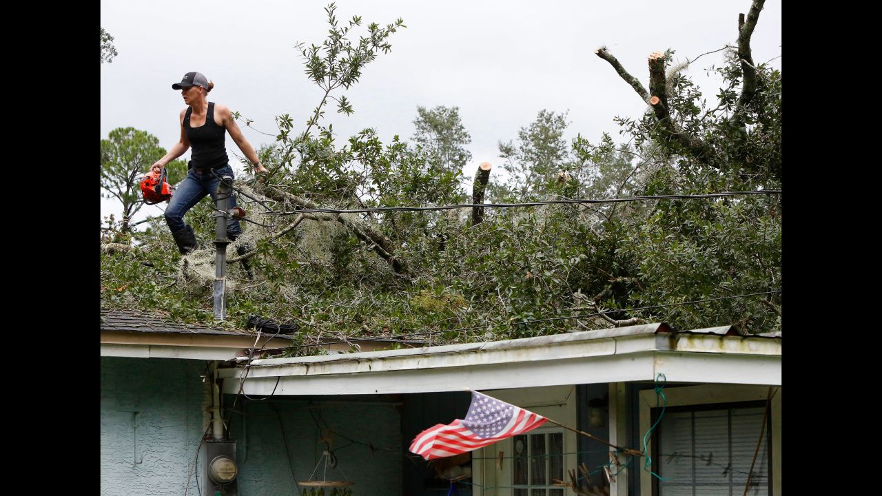 Ashley Tomberg drags a tree branch from the roof of a neighbor's house in Gainesville, Florida, on September 11.