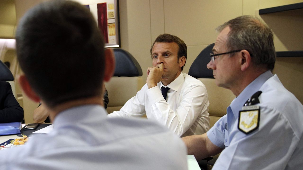 France's President Emmanuel Macron (2ndR) confers with officials aboard the presidential plane en route to Guadeloupe Island, the first step of his visit to French Caribbean islands, on September 12, 2017. 