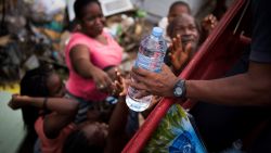 French firemen provide bottles of water to inhabitants of the Sandy Ground area of Marigot, on September 10, 2017 on Saint-Martin island, devastated by Hurricane Irma.