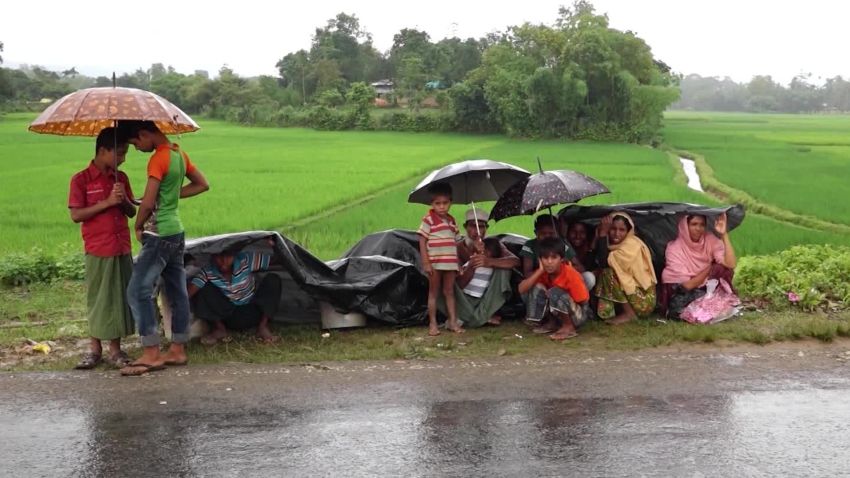 Rohingya refugees sit by the roadside, awaiting entrance into a refugee camp in Bangladesh. 