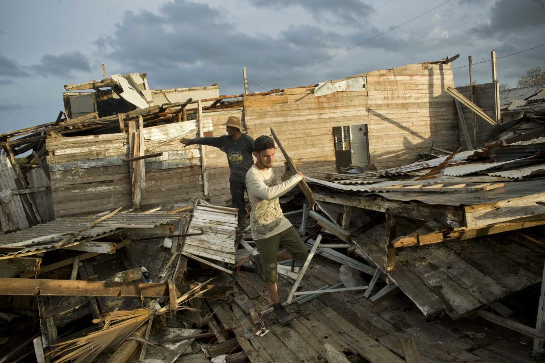 People salvage material from the remains of a house in Isabela de Sagua, Cuba, on September 11.