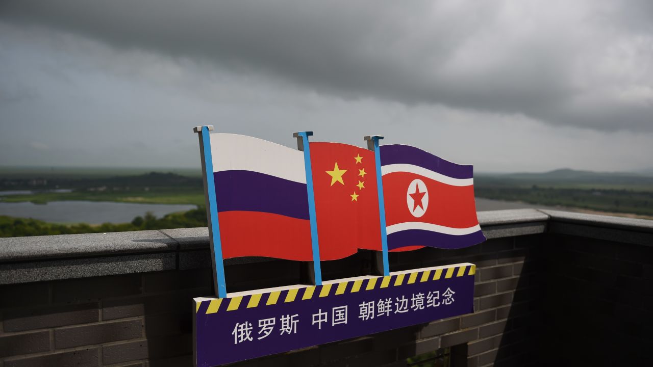 This photo taken on June 25, 2015 shows the flags of Russia (L), China (C) and North Korea (R) on a viewing tower on the border between the three countries in Hunchun, China's northeast Jilin province. 