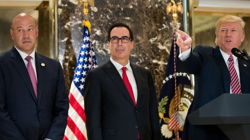 Director of the National Economic Council Gary Cohn and Treasury Secretary Steve Mnuchin look on as US President Donald Trump delivers remarks following a meeting on infrastructure at Trump Tower, August 15, 2017 in New York City. 