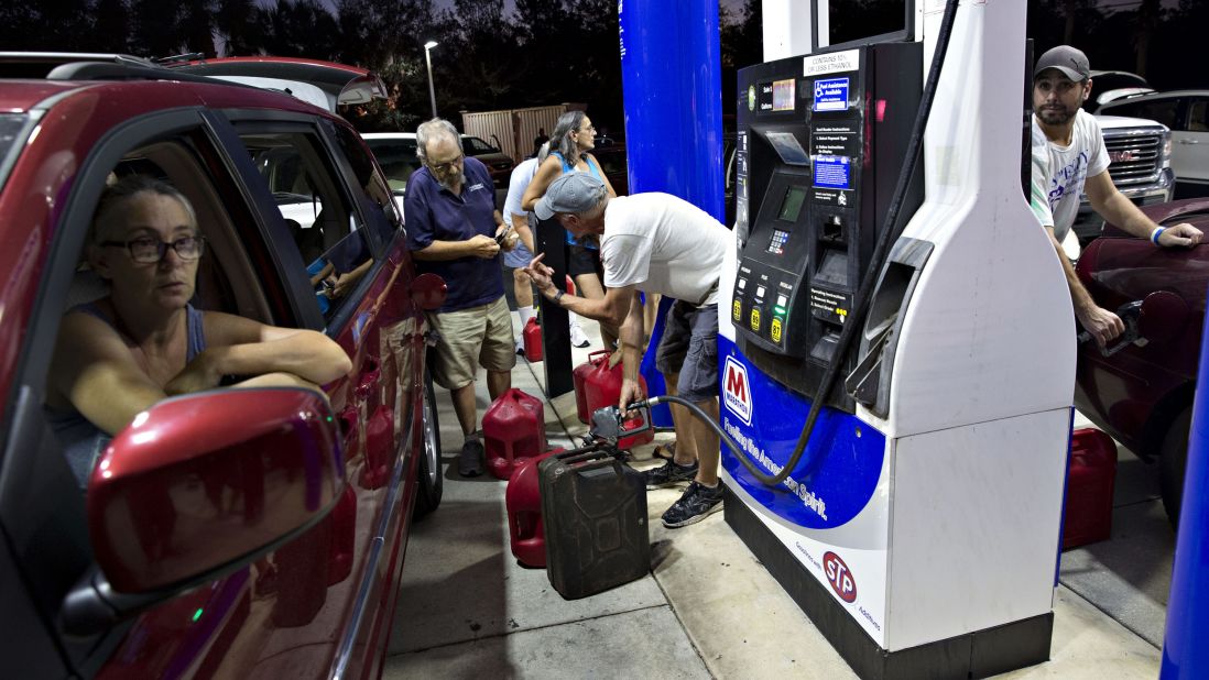 Motorists in Estero, Florida, fill gas cans September 12, moments before police shut the station down because of a curfew.