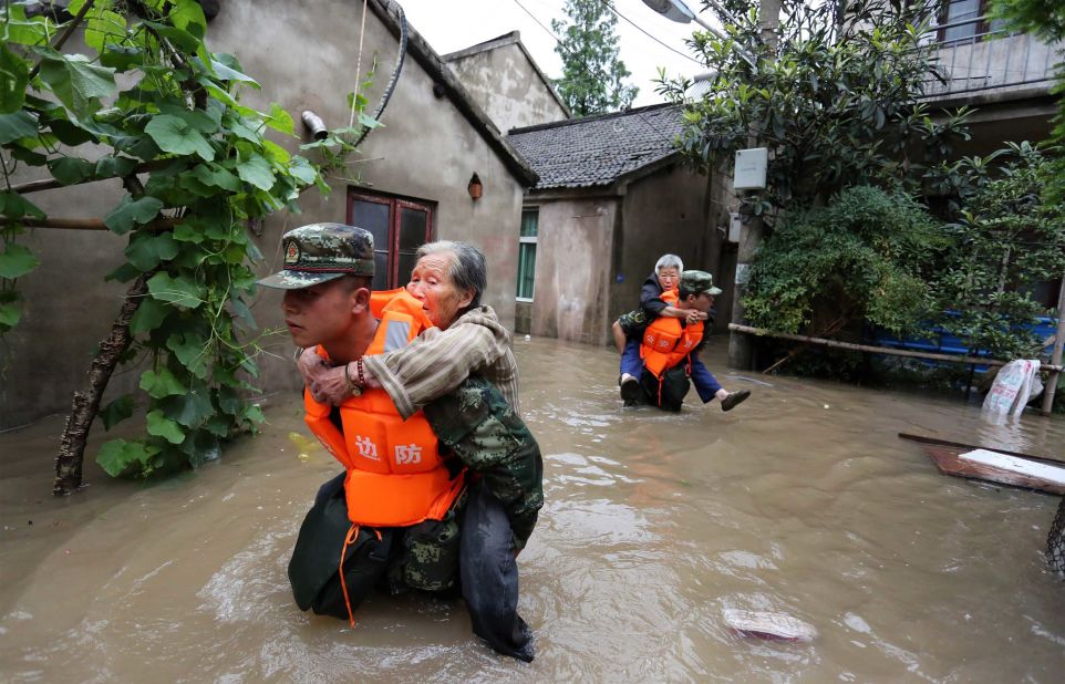 During a period of heavy flooding in Nanjing, paramilitary policemen carried residents from their homes.