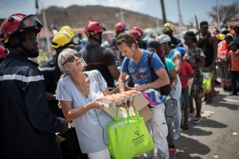 People collect food that was delivered by emergency workers in the Sandy Ground area of Marigot, St. Martin, on Tuesday, September 12.