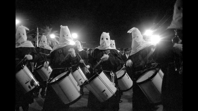 No, these men were not members of the Ku Klux Klan. They were marching around Easter time in Palermo and were probably members of a fraternity that did good deeds and, according to Stefano Albertini of Casa Italiana, covered their faces "not to hide, but to remain anonymous, because they perform acts of mercy for the glory of God." Once a Holy Week ritual, these parades have largely disappeared in Italy.