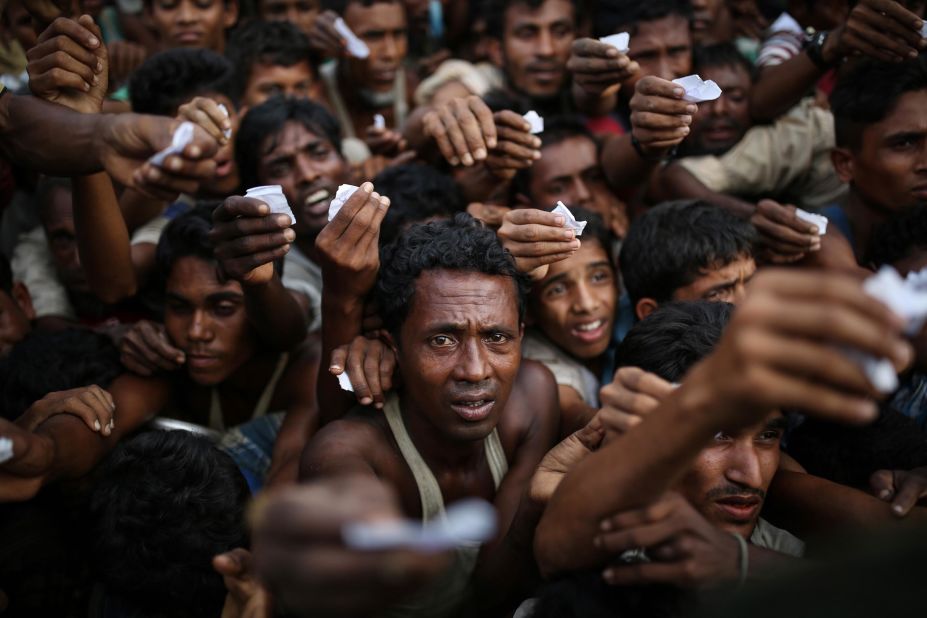 Rohingya men reach out for relief supplies on September 9, at a refugee camp in Bangladesh.