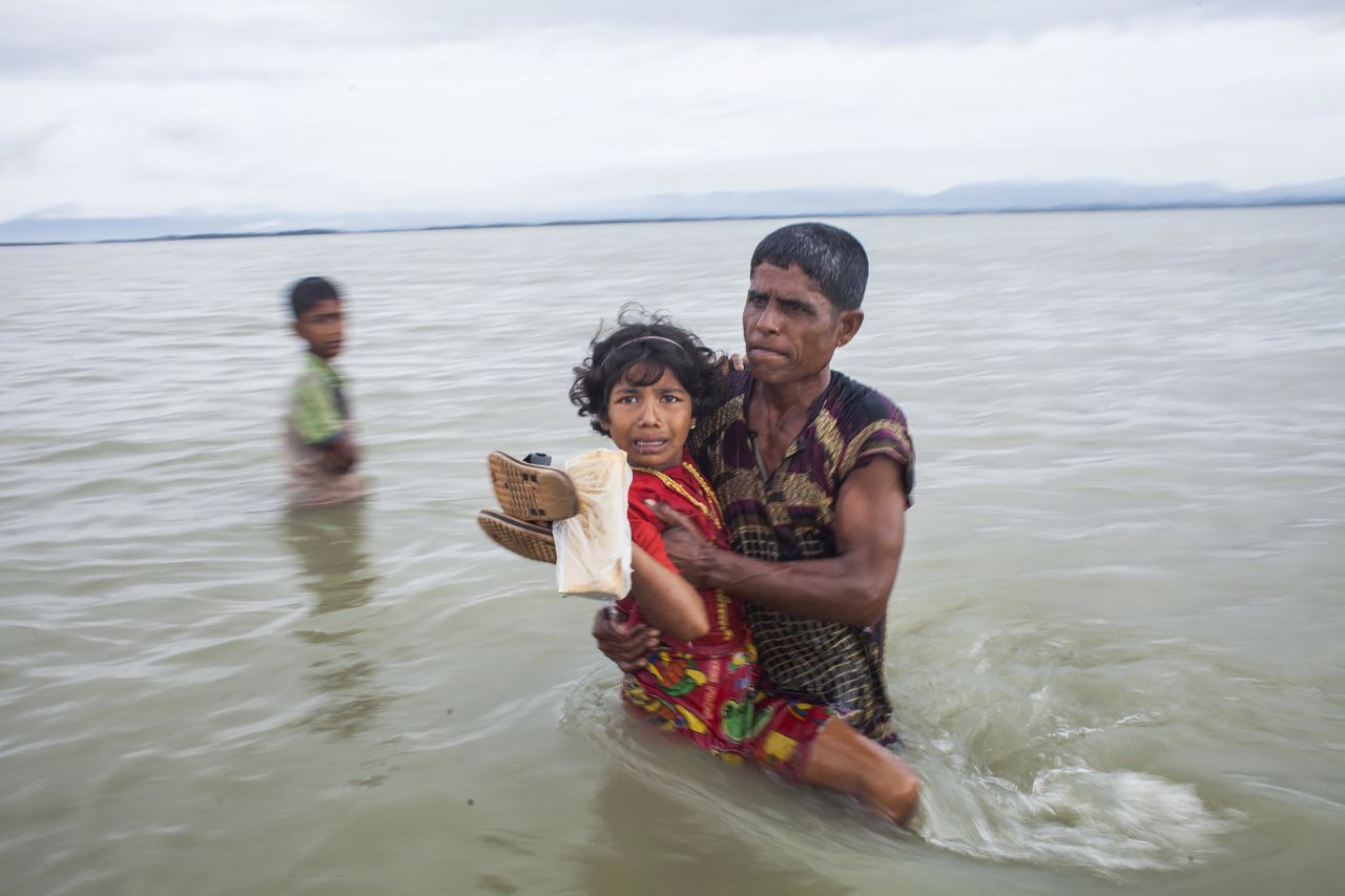 A girl is carried to safety after crossing the Naf River on September 9.