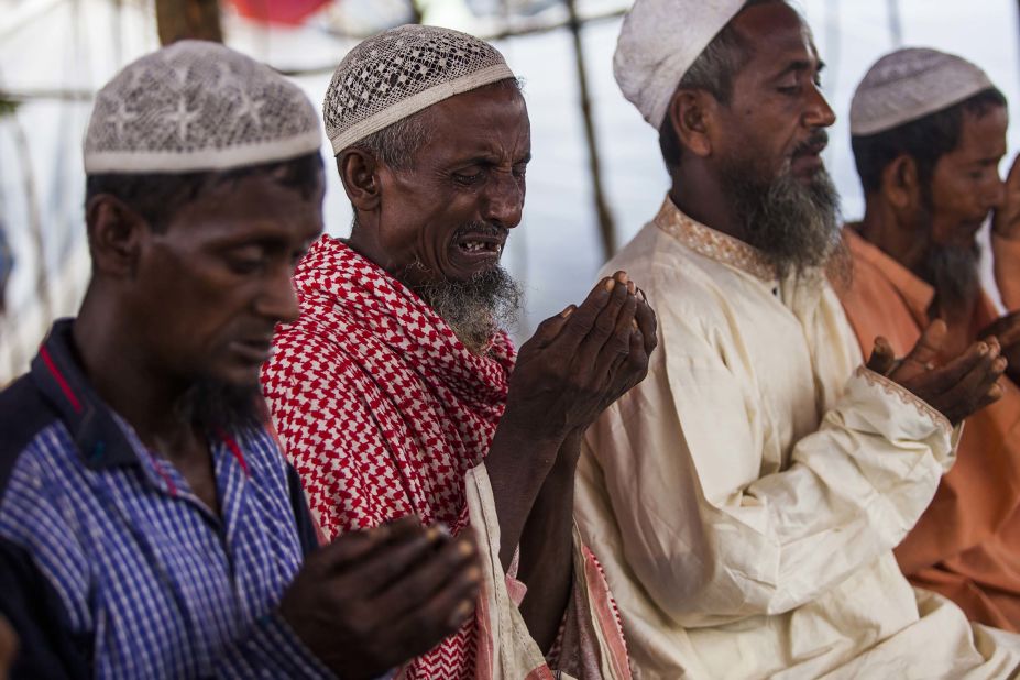 Rohingya men pray on September 11, in a makeshift shelter near Cox's Bazar.