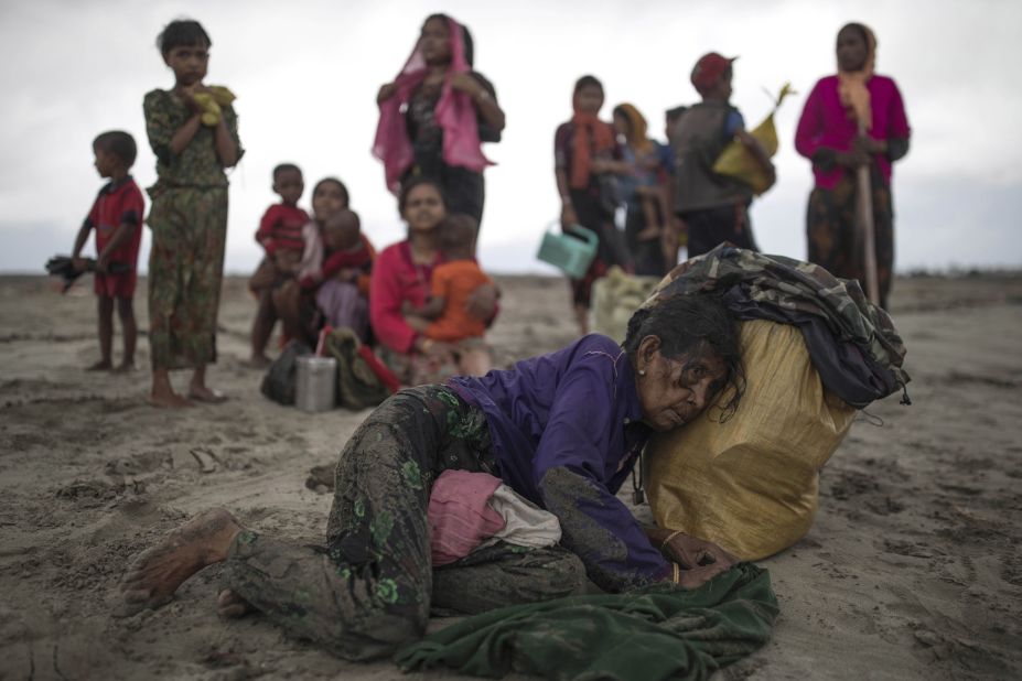 A woman collapses on September 12, after the wooden boat she and other refugees were traveling in crashed into the shore in Dakhinpara, Bangladesh.