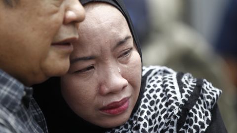 Family members cry outside the school.
