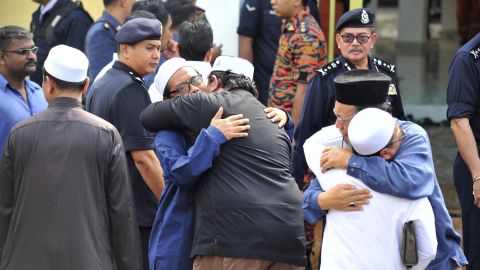People console each other outside an Islamic religious school following the fire.