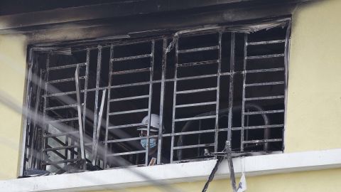 A forensic police officer investigates burnt windows at an Islamic religious school following the fire.
