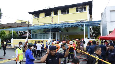 Police and rescue personnel work at an Islamic religious school in Kulala Lumpur that was cordoned off after a fire on September 14.