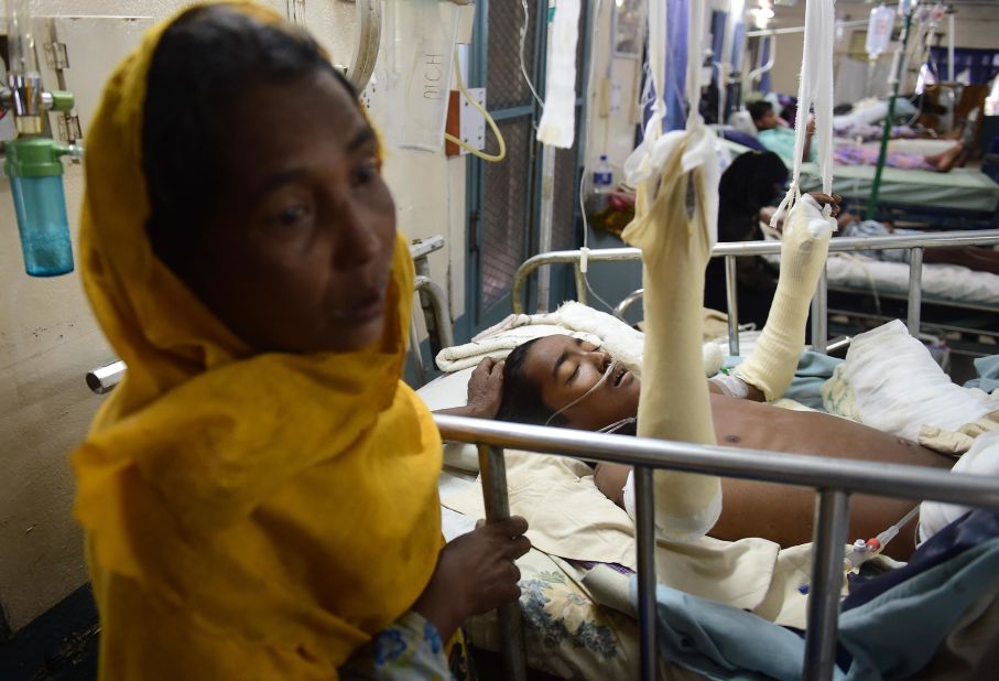 Rohingya refugee Rashida Begum stands next to her 15-year-old son, Azizul Hoque, as he is treated on September 13, at a hospital in Cox's Bazar, Bangladesh. He sustained a landmine injury while crossing from Myanmar to Bangladesh.