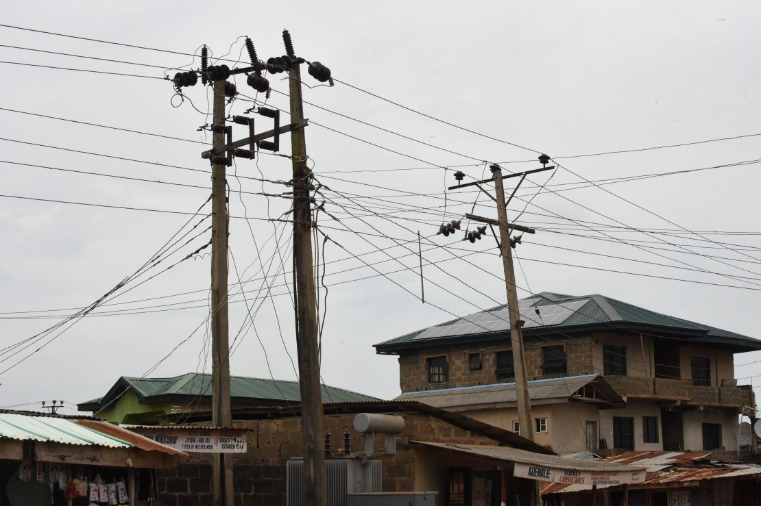 Public power cables and transformers stand across solar panels mounted on the roof top of a building as an alternative power supply in Lagos.