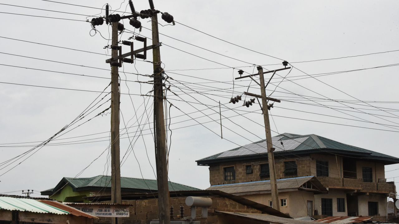 Public power cables and transformers stand across solar panels mounted on the roof top of a building as an alternative power supply in Lagos.