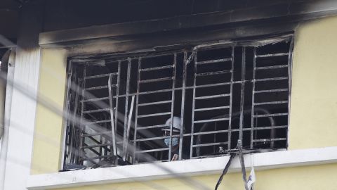 A forensic police officer investigates burned windows at an Islamic religious school following a fire on September 14, on the outskirts of Kuala Lumpur, Malaysia.