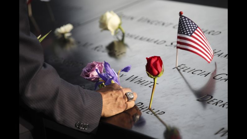 On the 16th anniversary of the 9/11 attacks, a man places a flower at the National September 11 Memorial in New York.