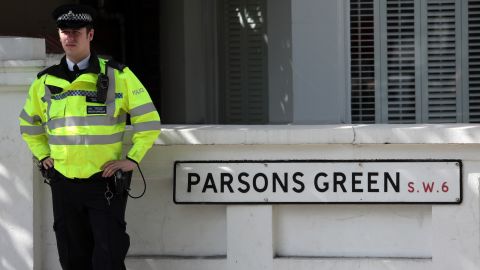 An officer stands next to a street sign near Parsons Green Underground Station on Friday.