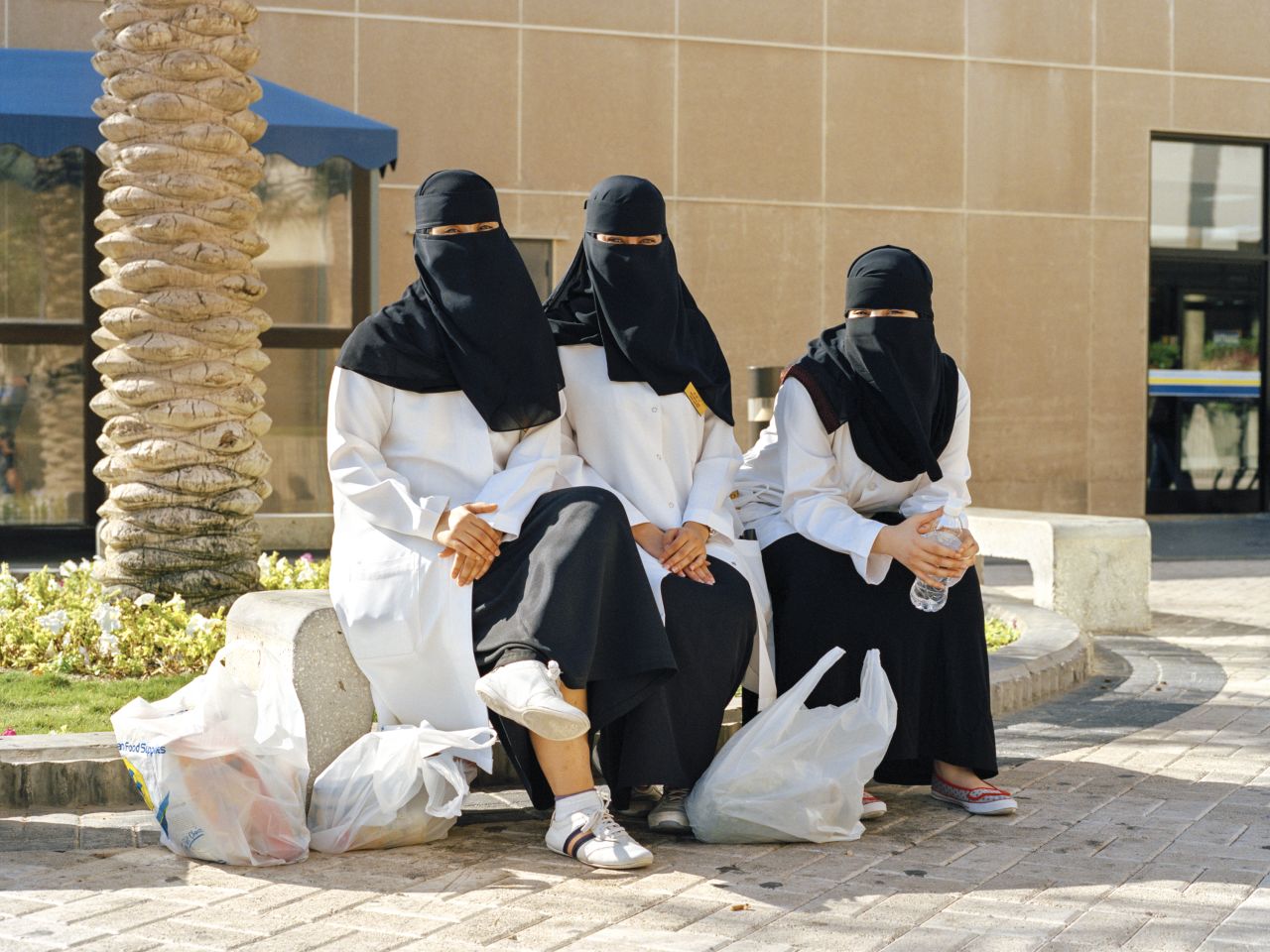 Nurses from Dhahran Health Center waiting for a bus outside the commissary.