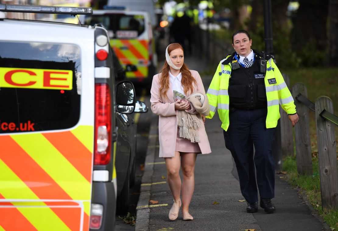 An injured woman is escorted from the scene at Parsons Green Underground Station.