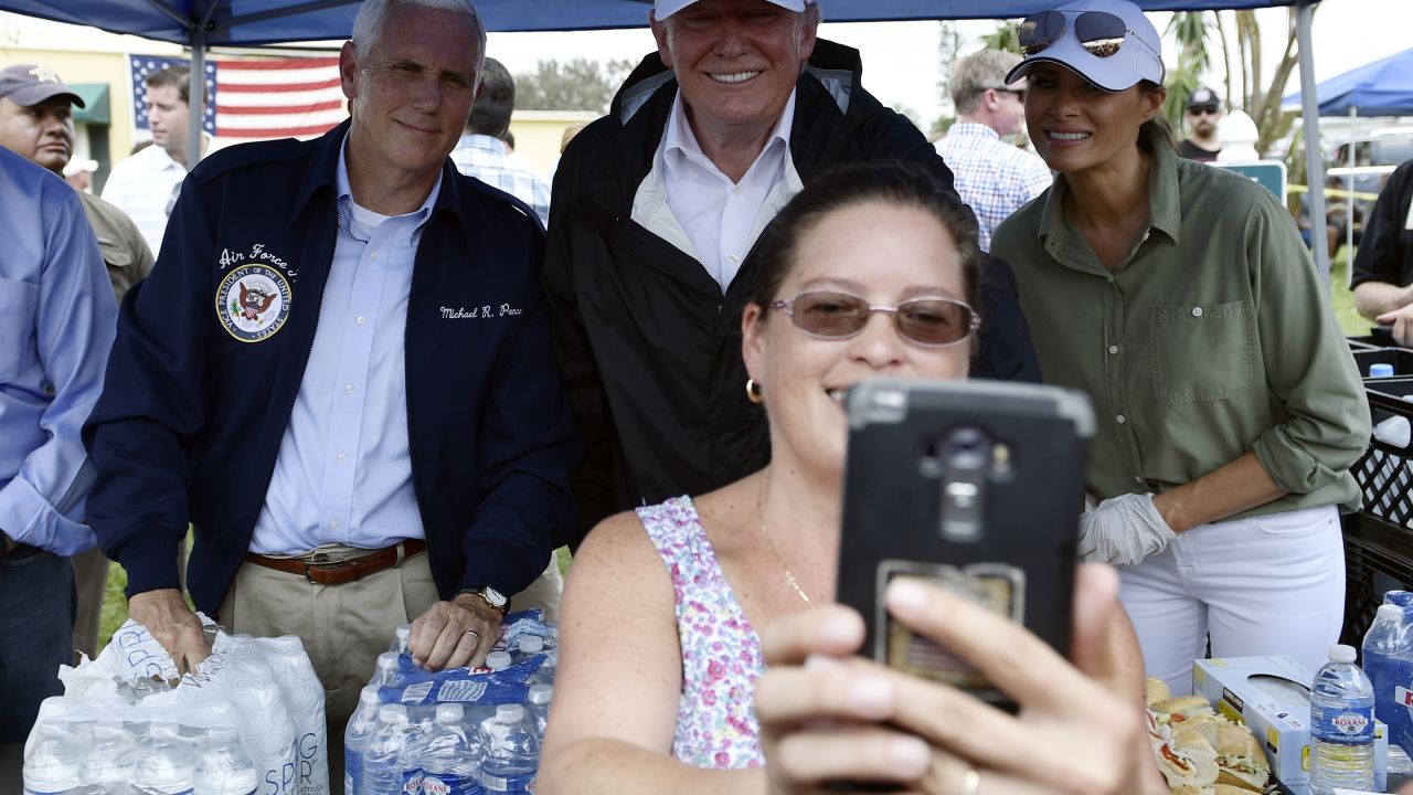 First lady Melania Trump poses for a selfie with her husband, President Trump, as they help serve food to people affected by Hurricane Irma, in Naples, Florida, on September 14, 2017.