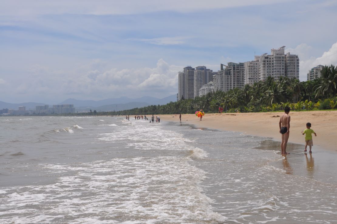 Father and son play on Sanya Bay beach in southern Hainan Island, China.