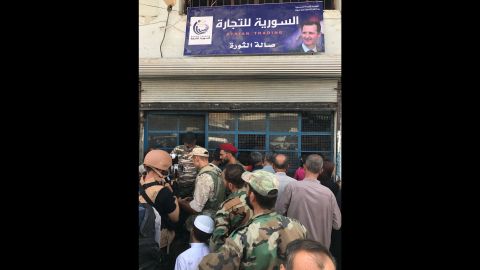 People line up outside a small store in central Deir Ezzor.