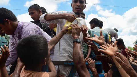 Rohingya refugees from Myanmar grab onto a bag of food from a man on a truck delivering aid in Ukhia on September 14.