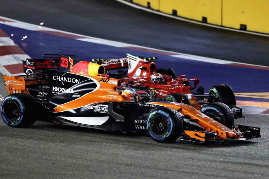 Count the cars... McLaren's Fernando Alonso, Max Verstappen and Kimi Raikkonen collide at the first corner on lap one of the Singapore Grand Prix.  