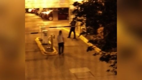 A still image taken from cellphone video shows Schultz, in the white shirt, walking toward an officer.