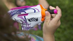 A young girl loads a foam bullet into a Hasbro Inc. Nerf Rebelle toy gun in Tiskilwa, Illinois, U.S., on Thursday, July 16, 2015. Hasbro Inc. is expected to report quarterly earnings on July 20, 2015. Photographer: Daniel Acker/Bloomberg via Getty Images