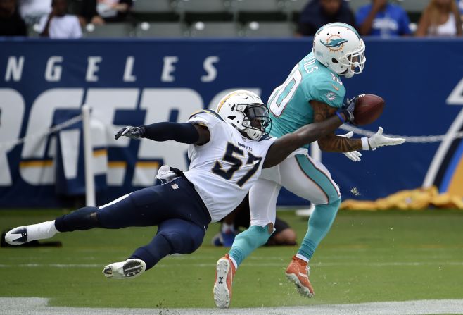 Miami wide receiver Kenny Stills makes a touchdown catch as Los Angeles Chargers linebacker Jatavis Brown tries to get his hand on the ball during the second half of an NFL game on Sunday, September 17.