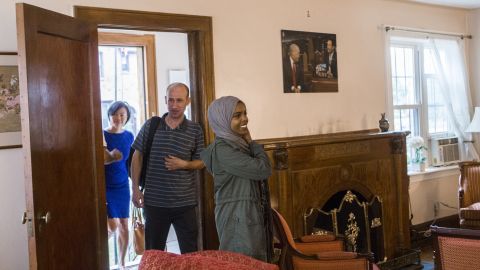From left to right: Uyen Nguyen, Ghassan Shehadeh and Eiman Ali, who all came to the US as refugees, walk into the living room of Trump's childhood home.