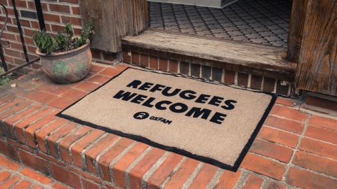 A mat outside the front door of Trump's childhood home displays the message "Refugees Welcome."