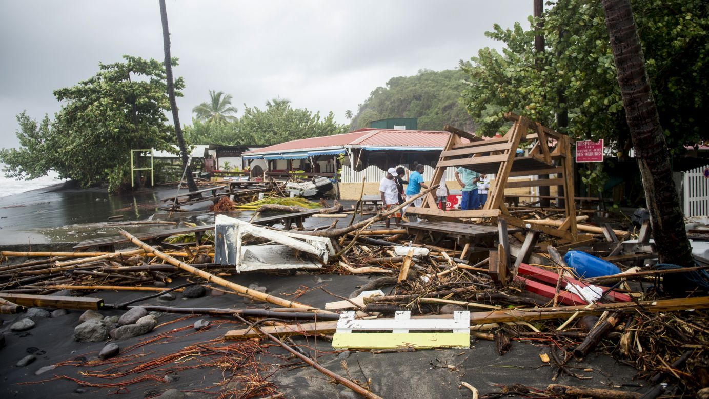 People stand near debris at a restaurant in Le Carbet, Martinique, on September 19.