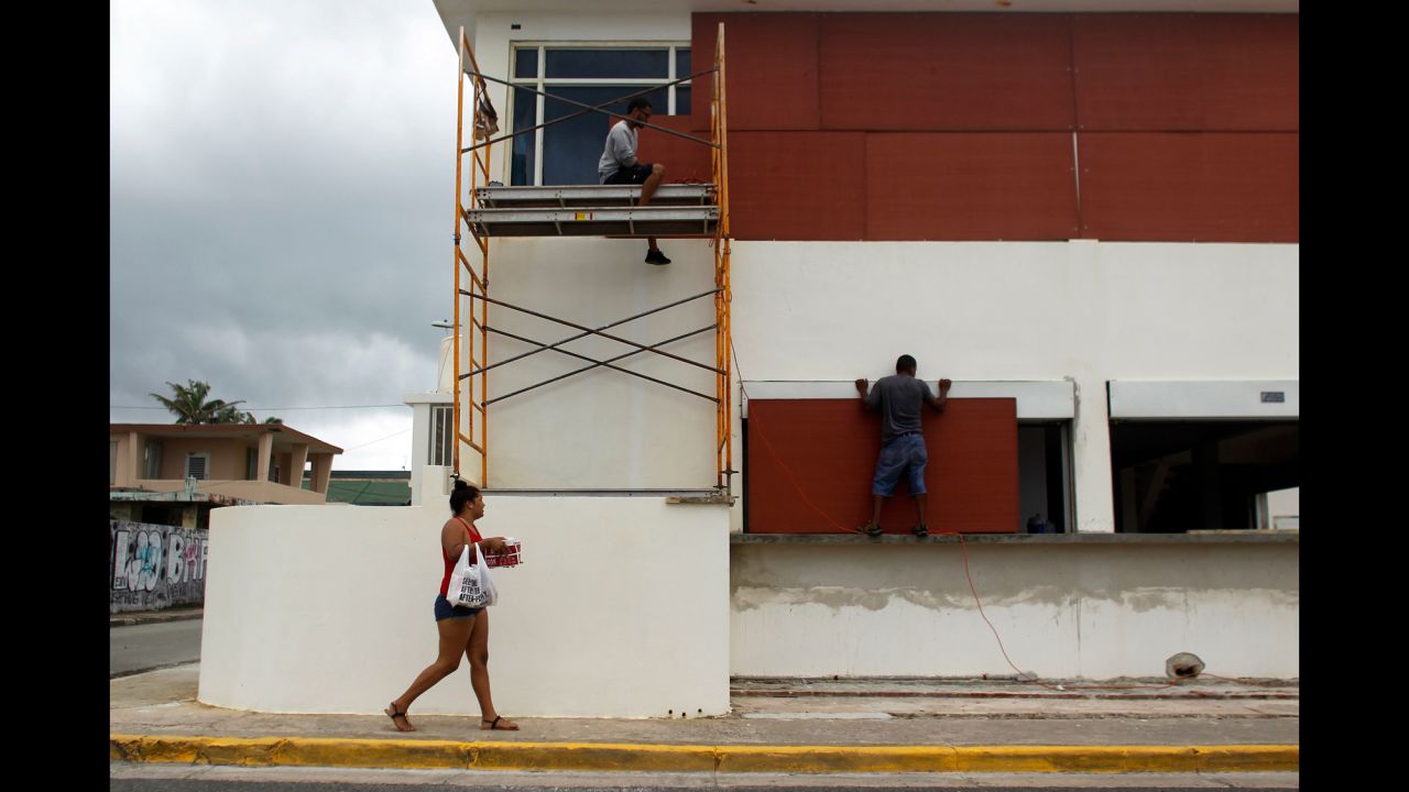 People in Luquillo, Puerto Rico, board up windows of a business on September 19.
