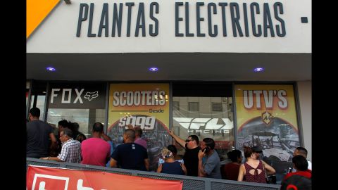Customers wait in line for power generators at a store in San Juan on September 18.