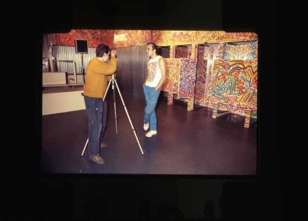 Haring being photographed in the Milan store in front of some of his work that featured on the walls. 