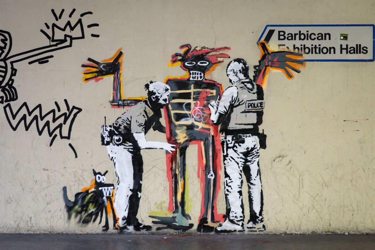 A new work by street artist Banksy, inspired by Basquiat's "Boy and Dog in a Johnnypump" (1982), on a wall near the Barbican in London. 