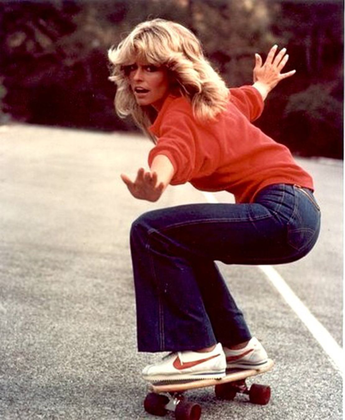 American actress Farrah Fawcett poses on a skateboard in Fiorucci's stretch denim. 